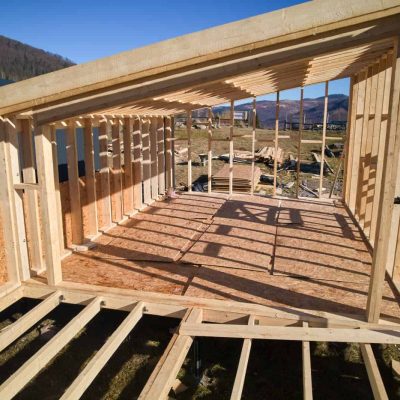 Timber frame house on pile foundation under construction in the mountains.
